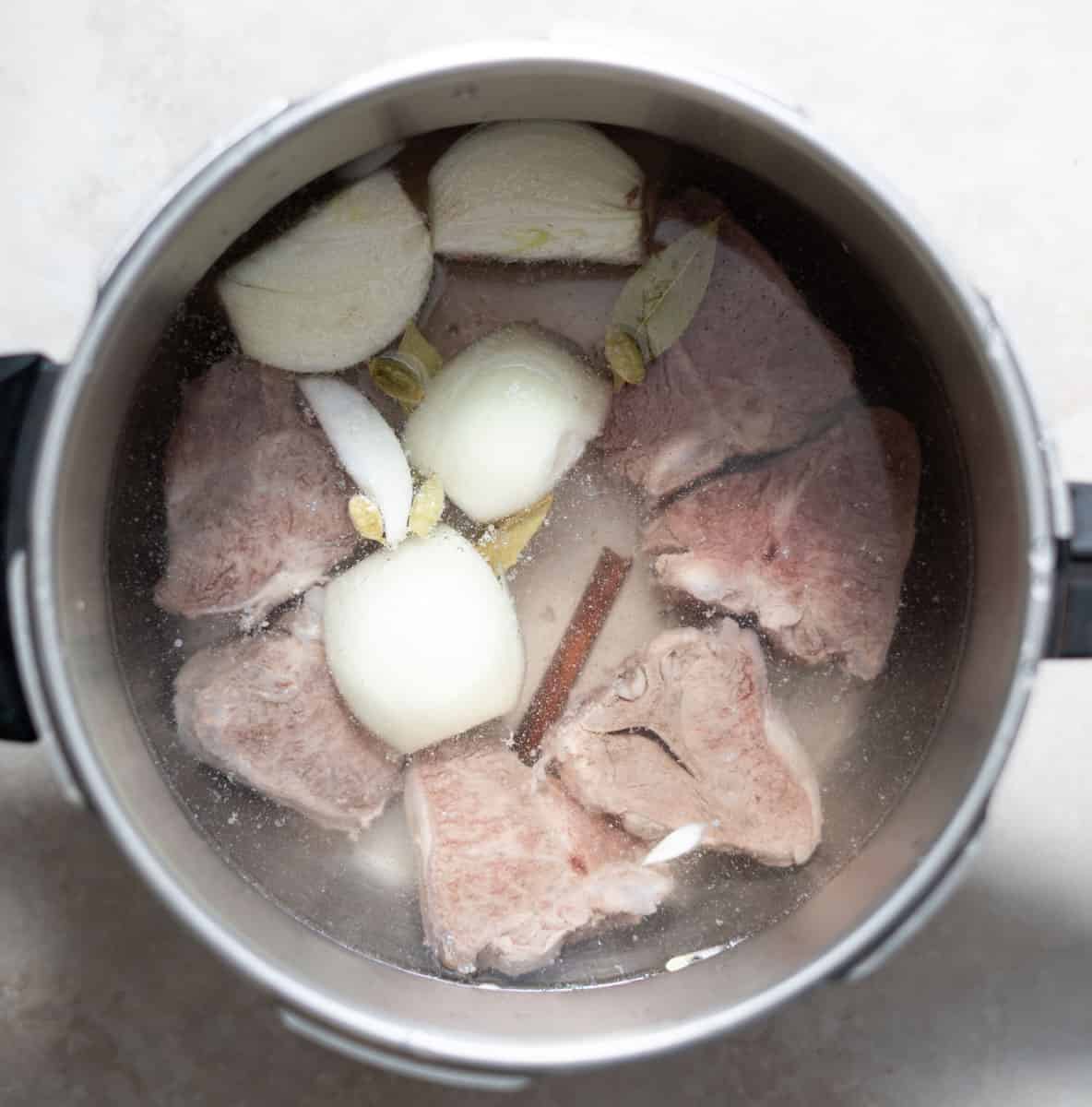 Lamb with spices covered with water in a pot