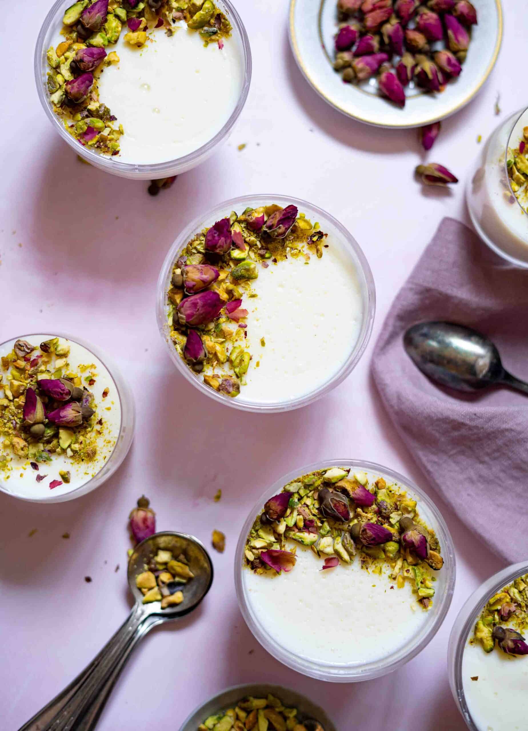 Muhallebi in small 5 plates, garnished with rose petals and pistachios