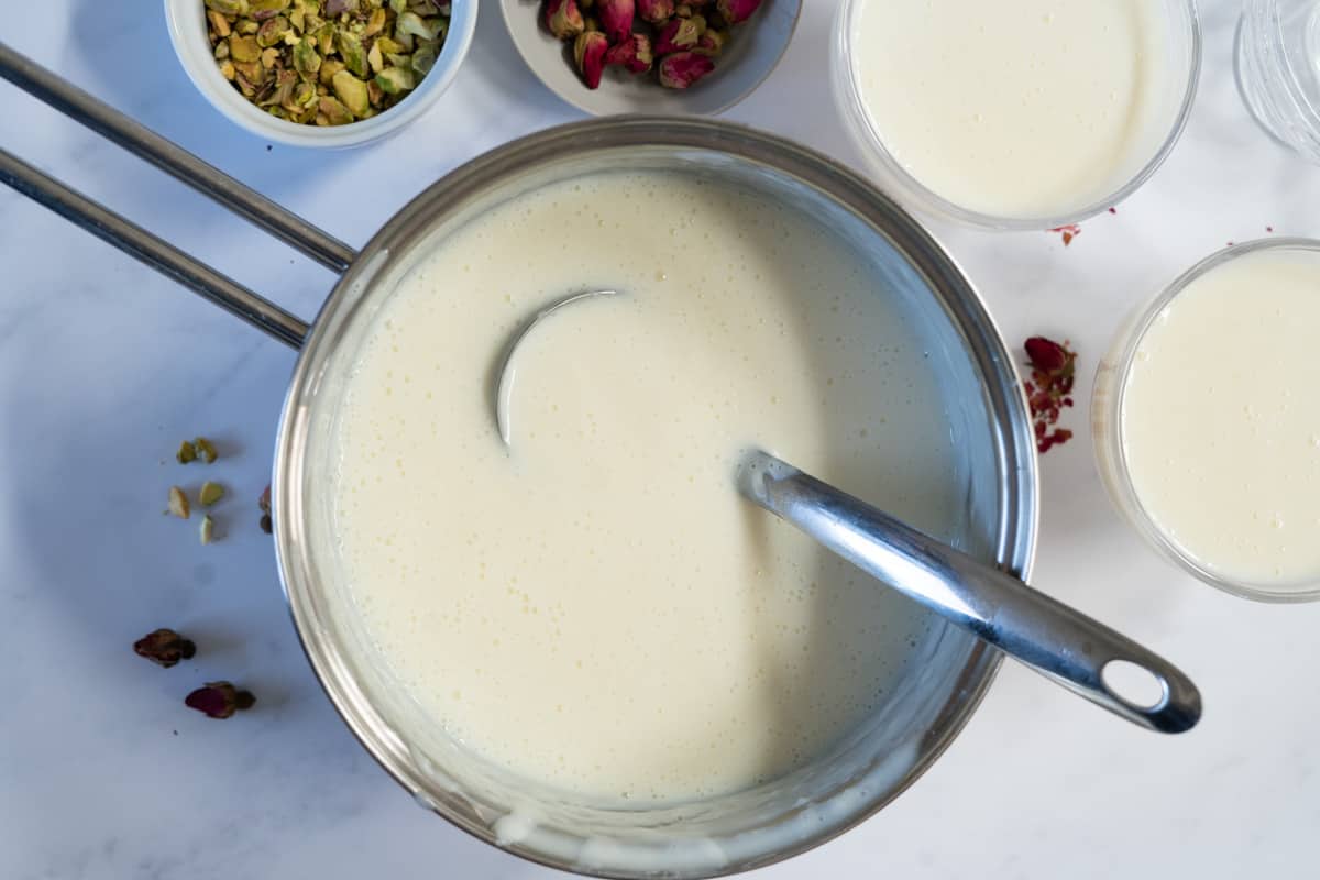 Pouring cooked Muhallebi from the pot into small plates.