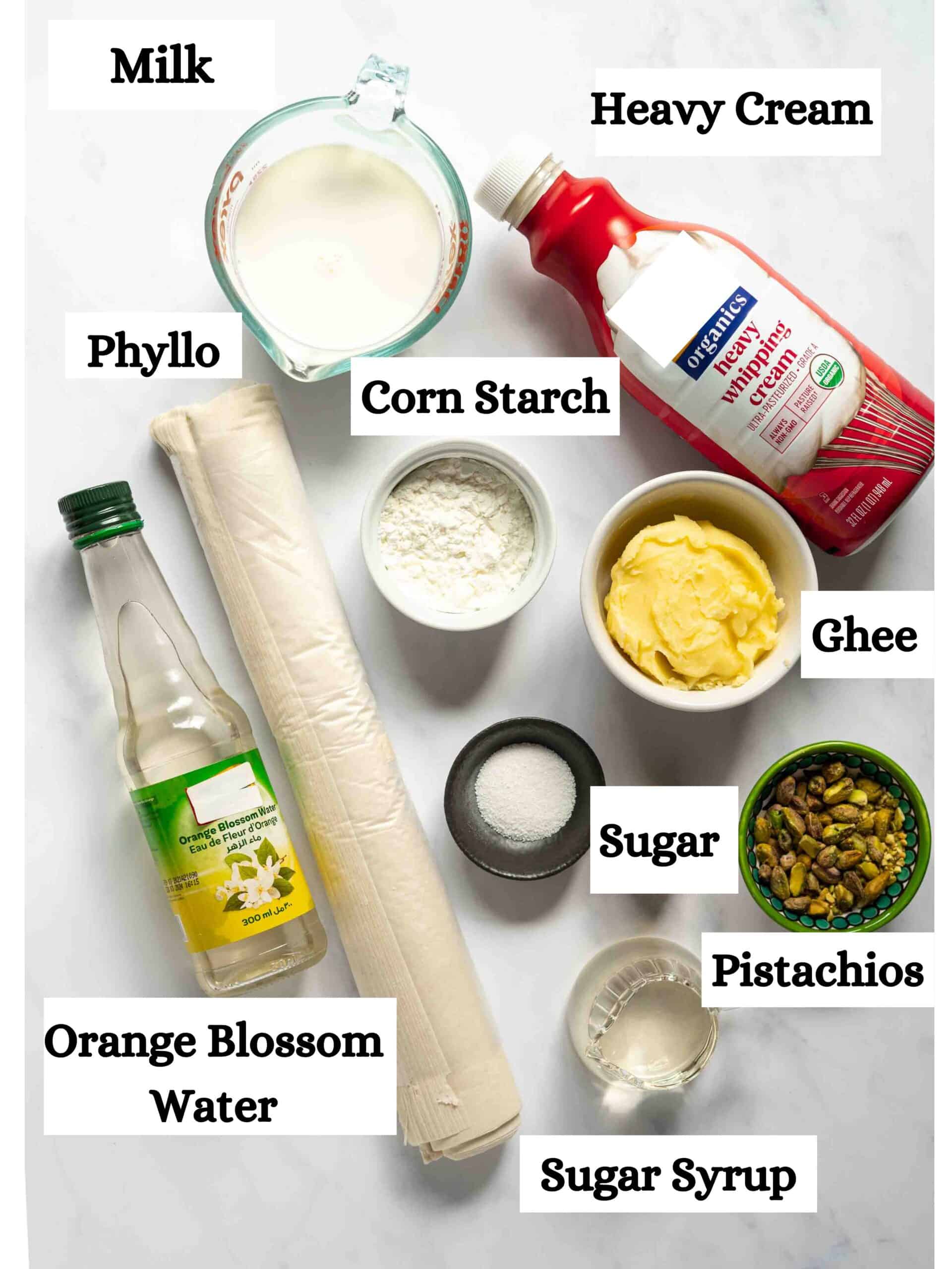 Warbat recipe ingredients: milk, heavy cream, phyllo dough, corn starch, ghee, sugar, pistachios, orange blossom water, sugar and sugar syrup.