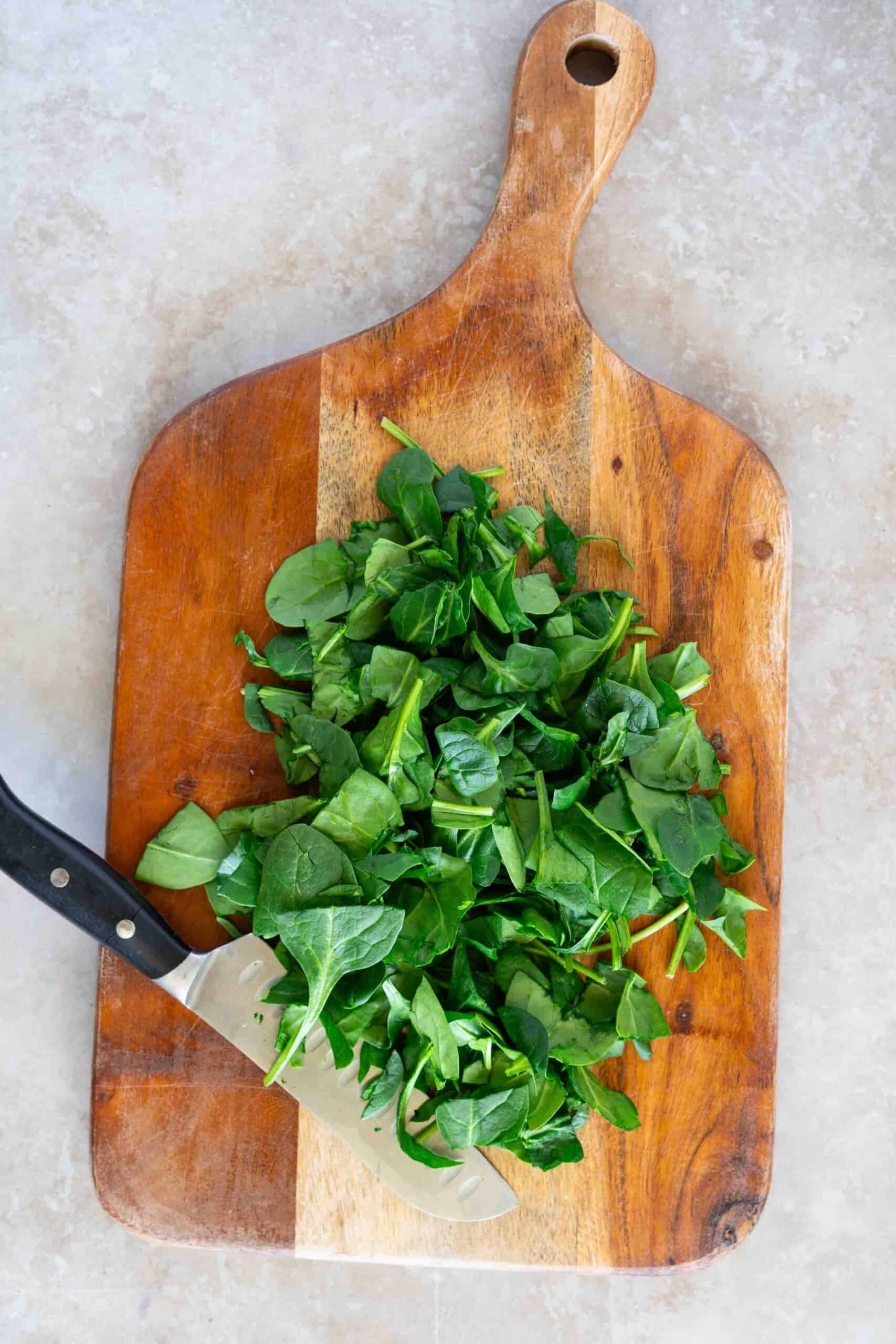 chopping spinach on a board