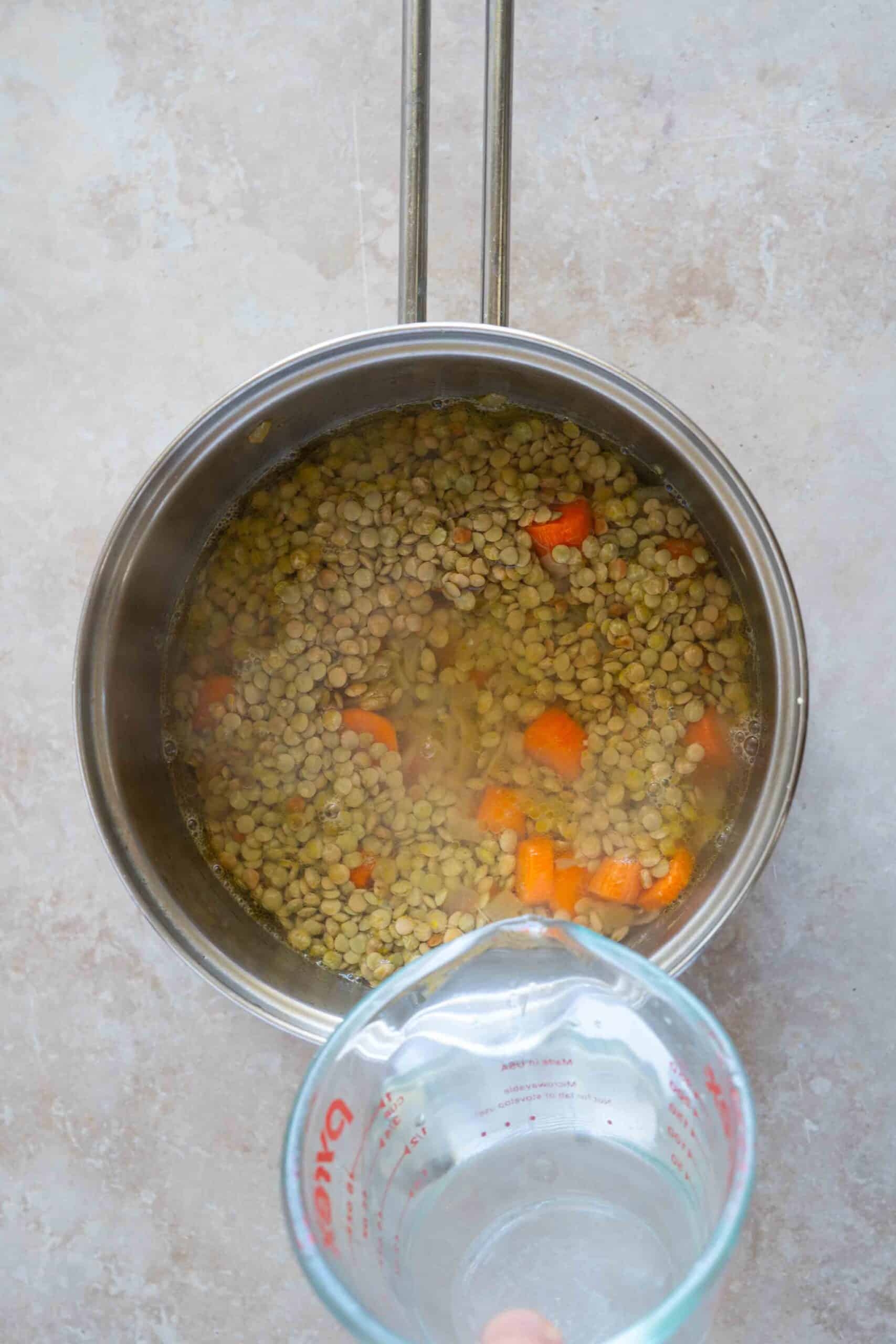 Pouring water over lentils in a pot
