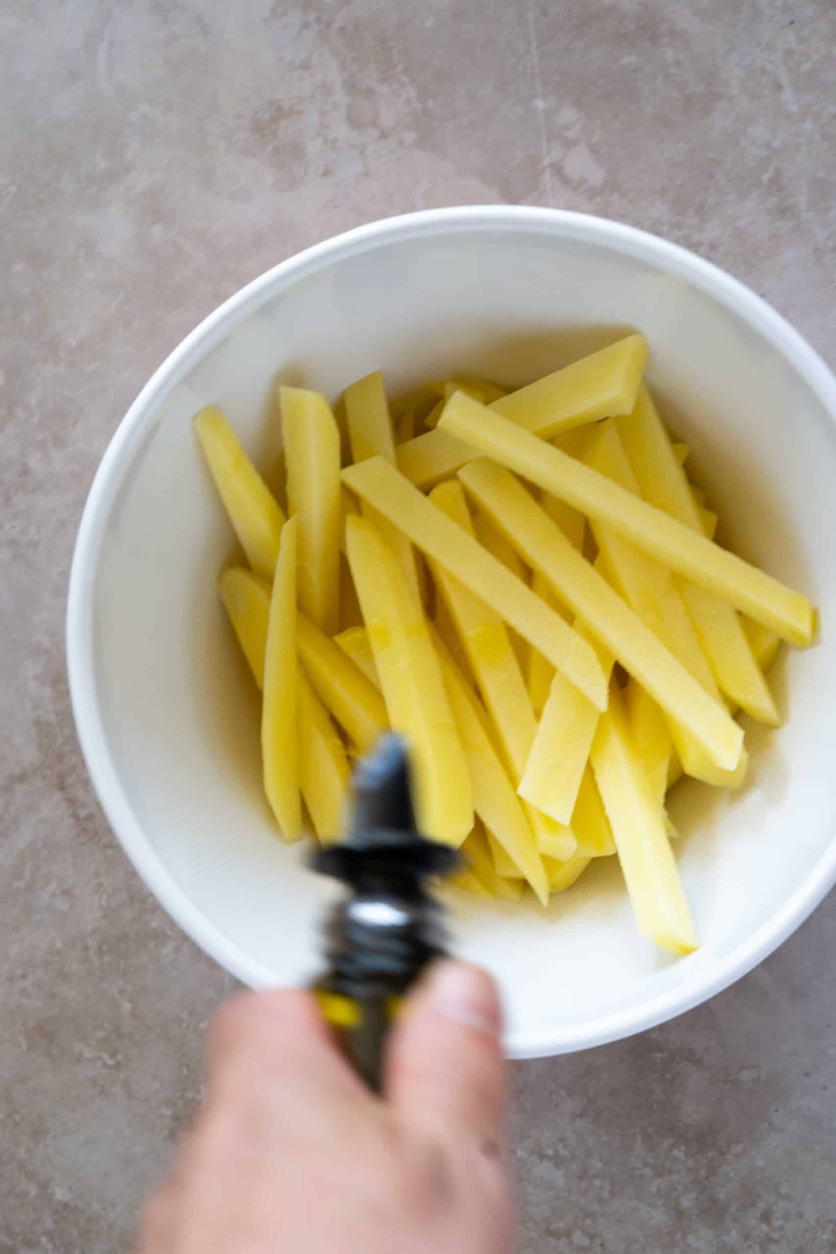 Pouring oil over potatoes