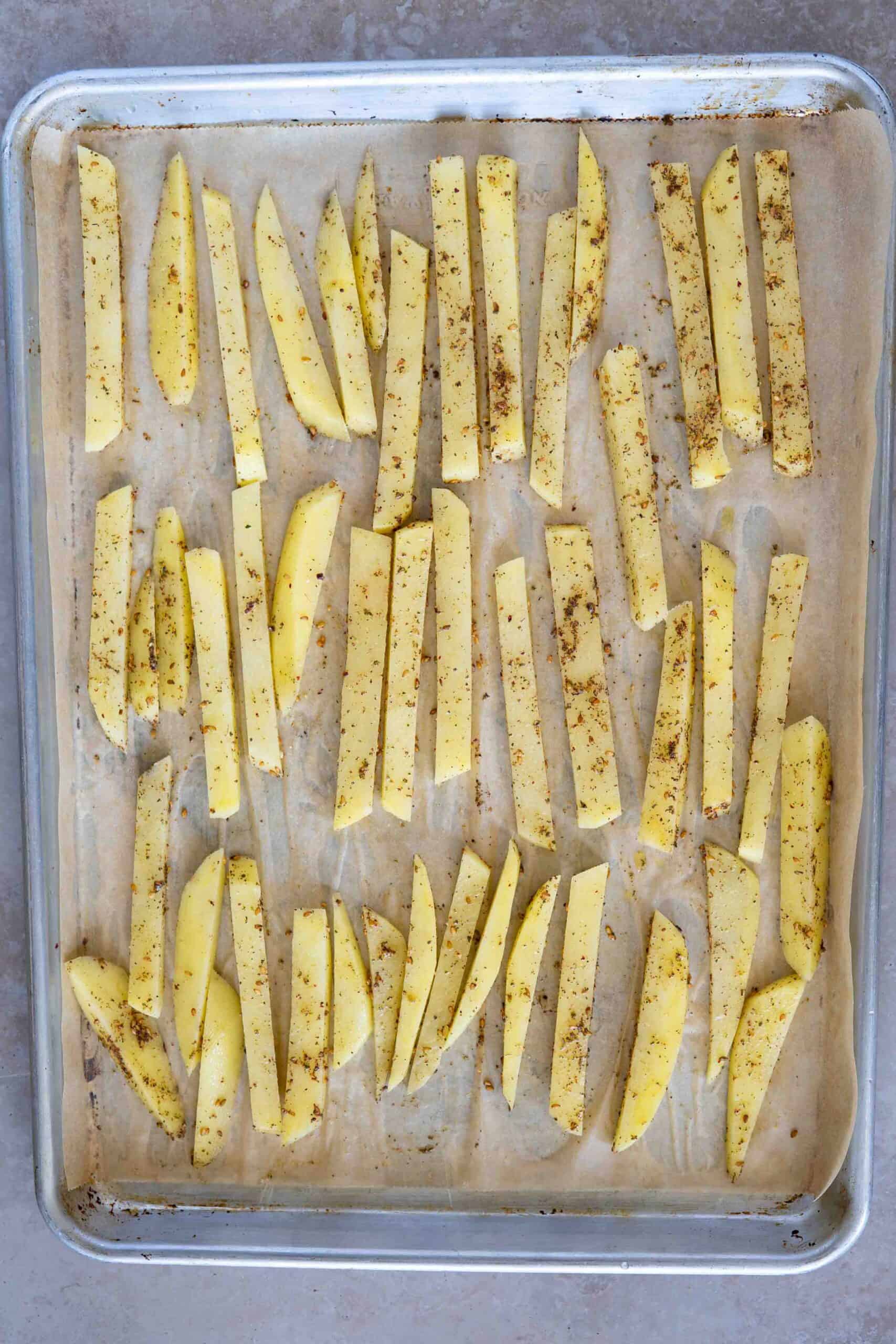 Sliced potatoes before baking on a baking sheet