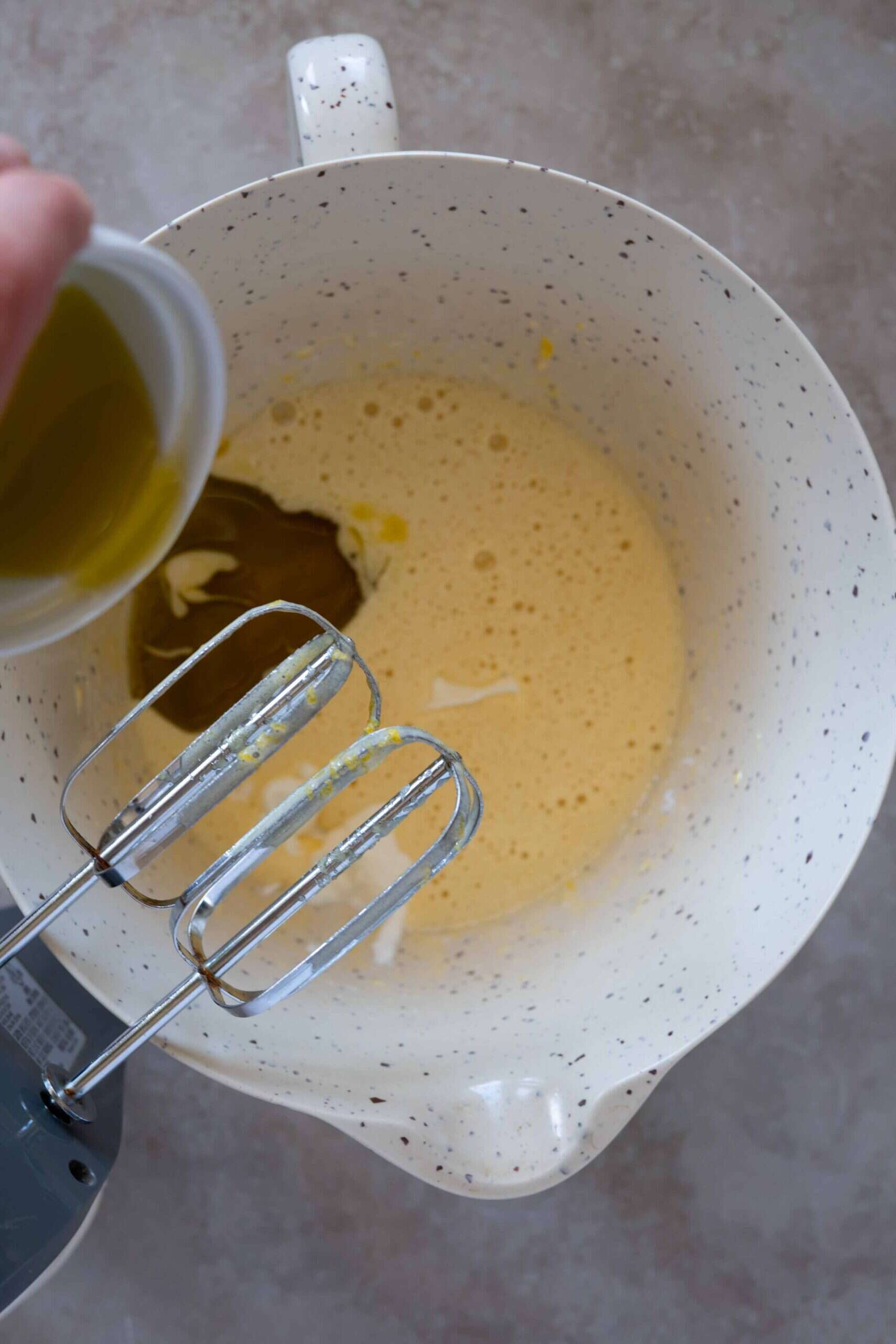 Adding olive oil to the mixture egg sugar mixture