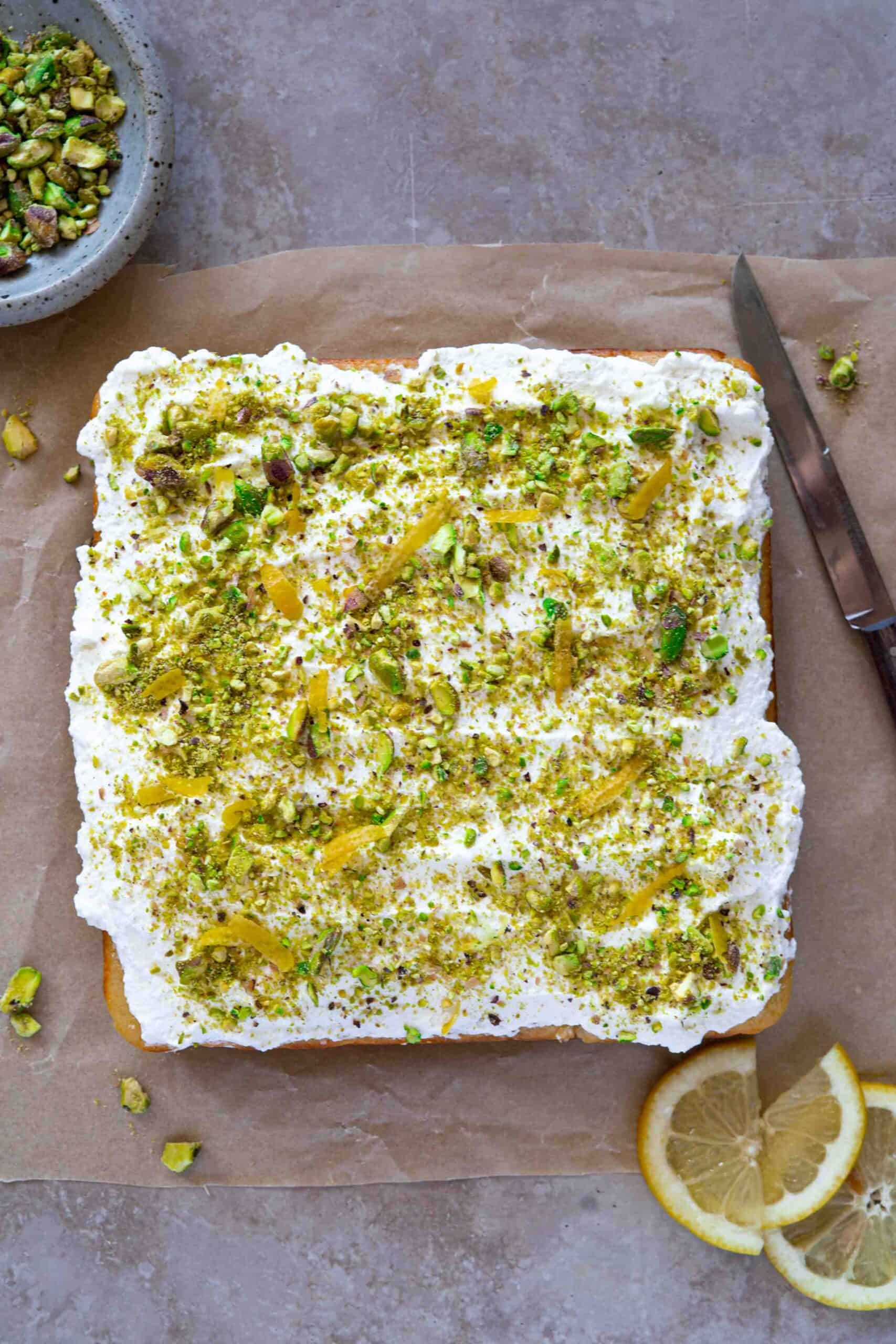 Cake covered with a layer of whipped cream and sprinkle generously with crushed pistachios