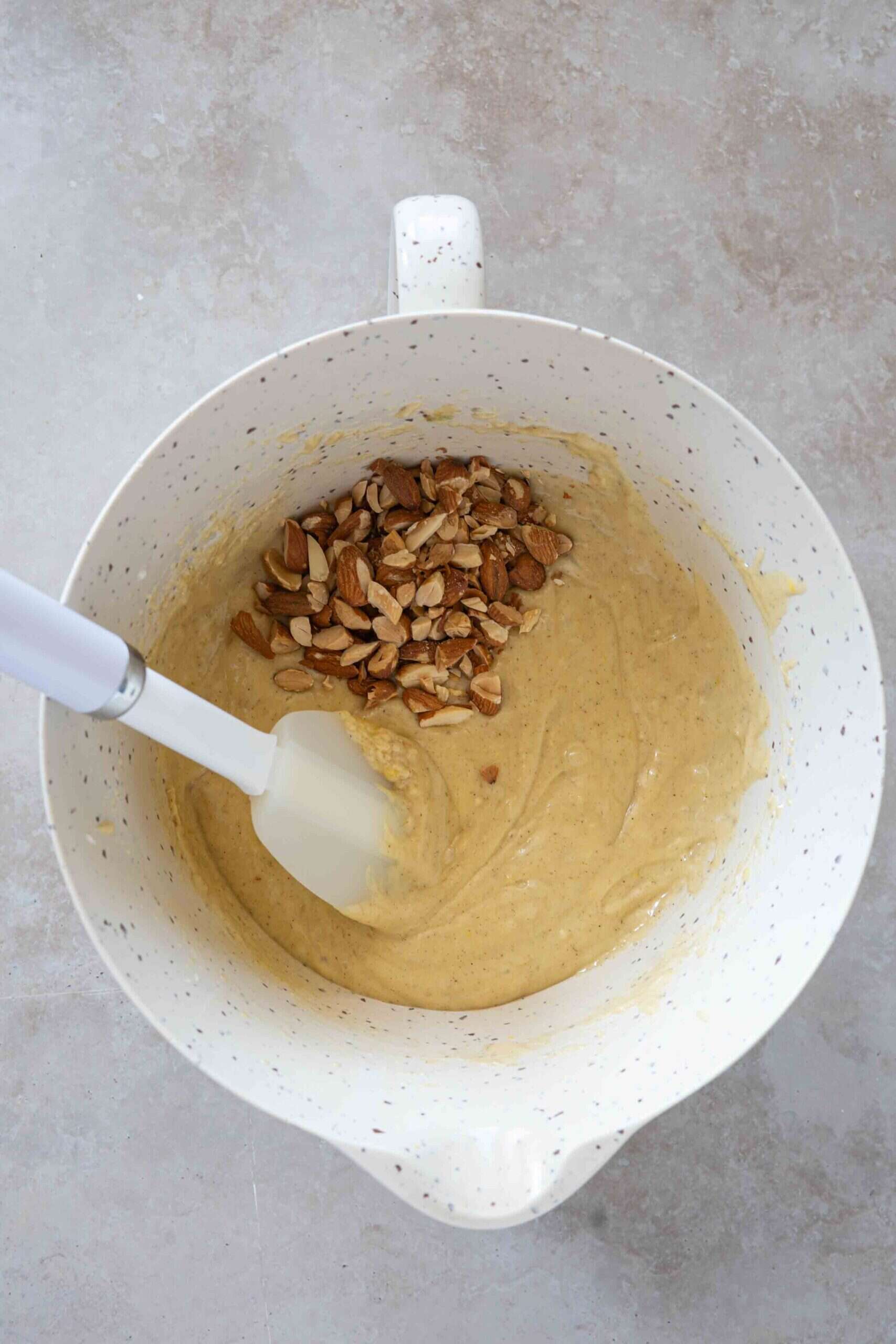 Adding toasted roughly chopped almonds to the cake batter.
