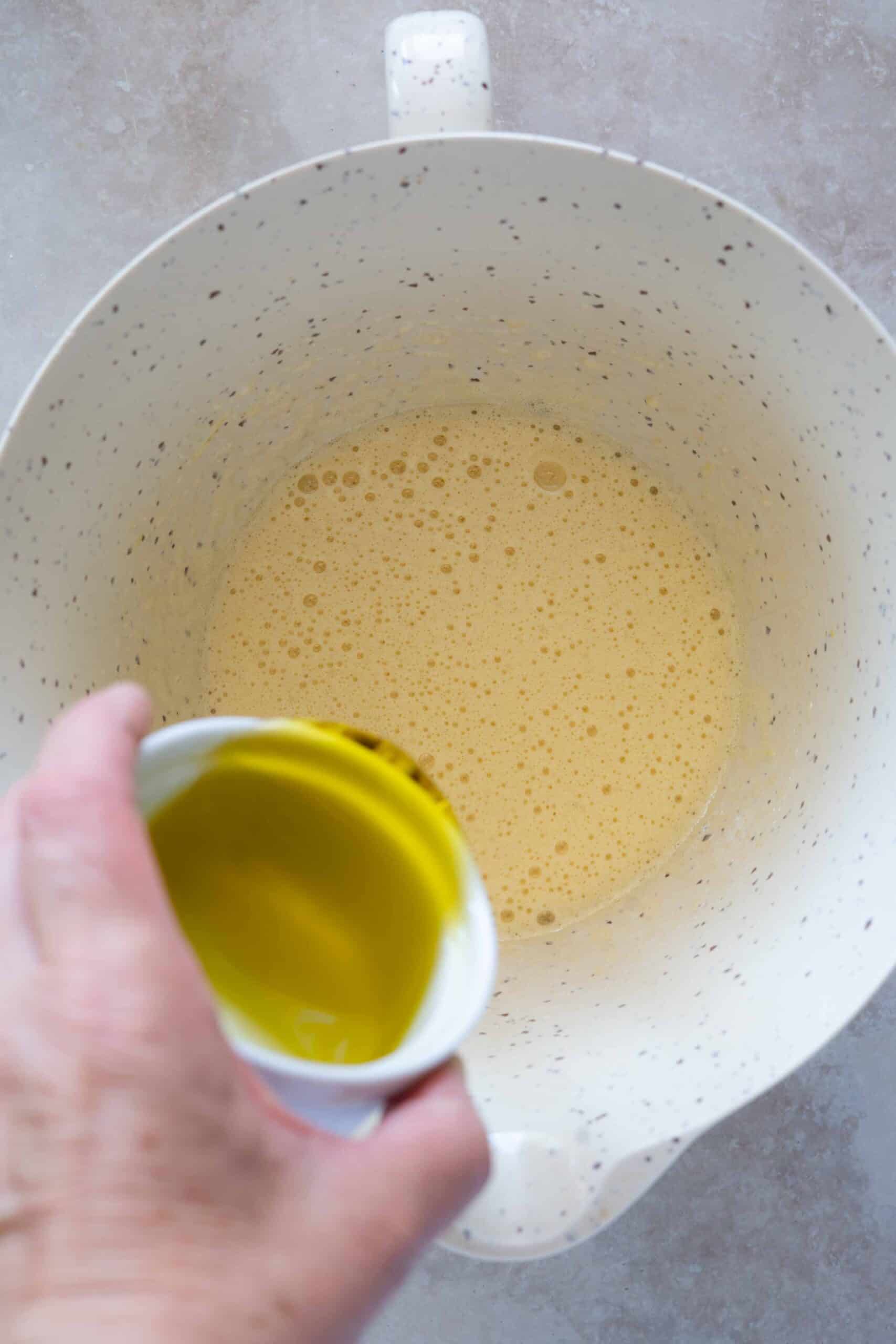 Adding olive oil over egg mixture