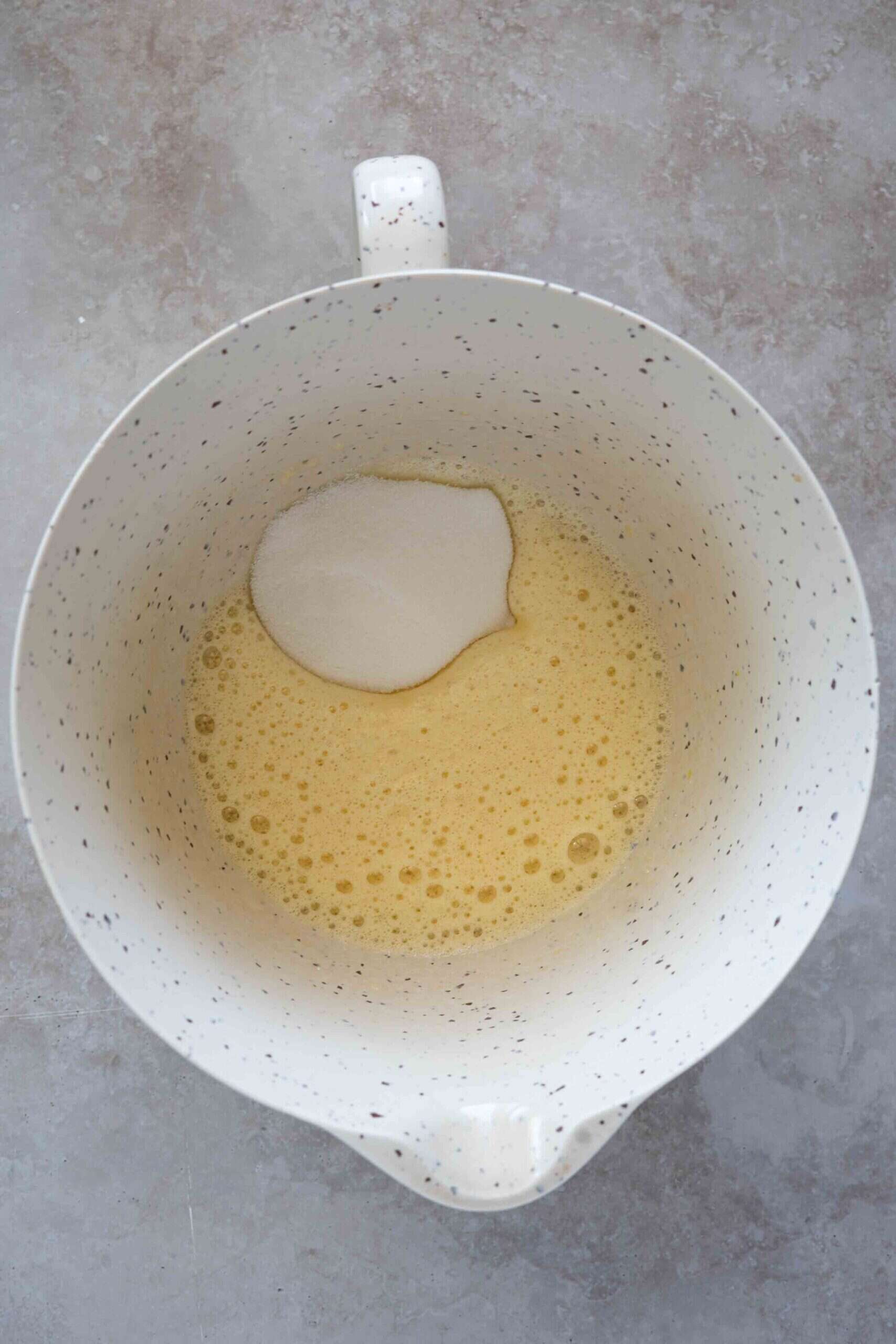 Adding sugar over egg mixture