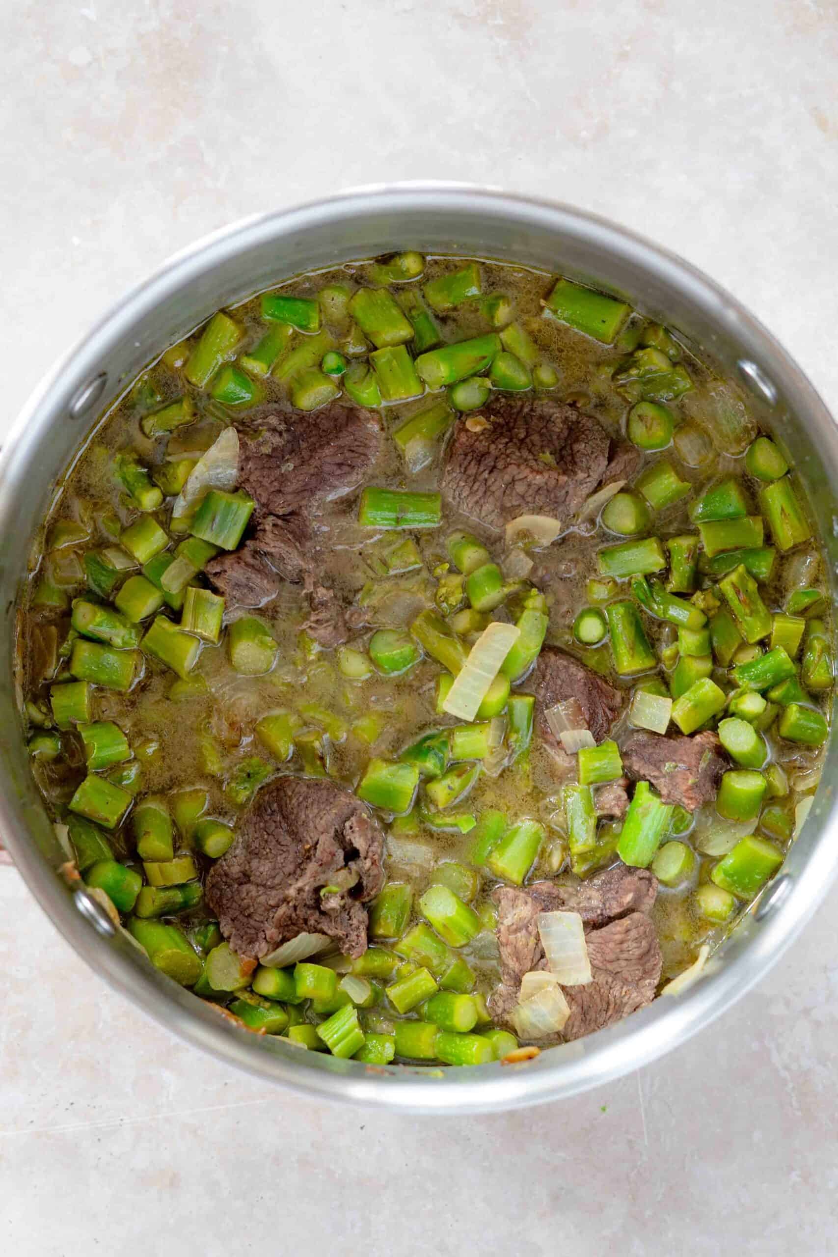 Cooked asparagus with meat in a pot ready for serving.