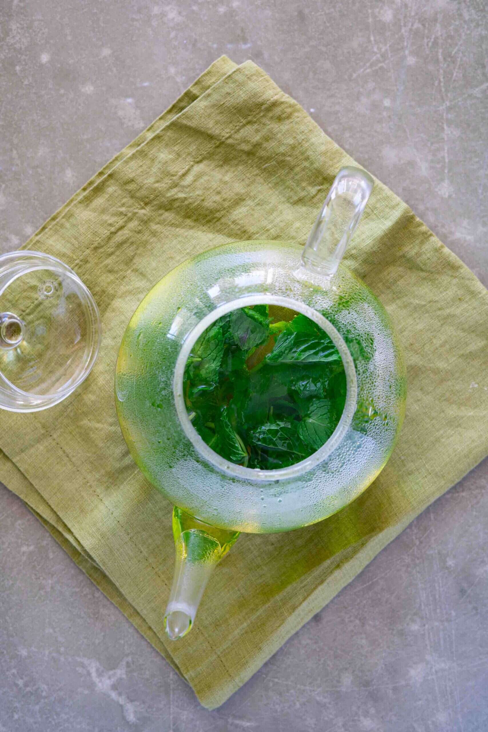 teapot filled with hot water and fresh mint leaves