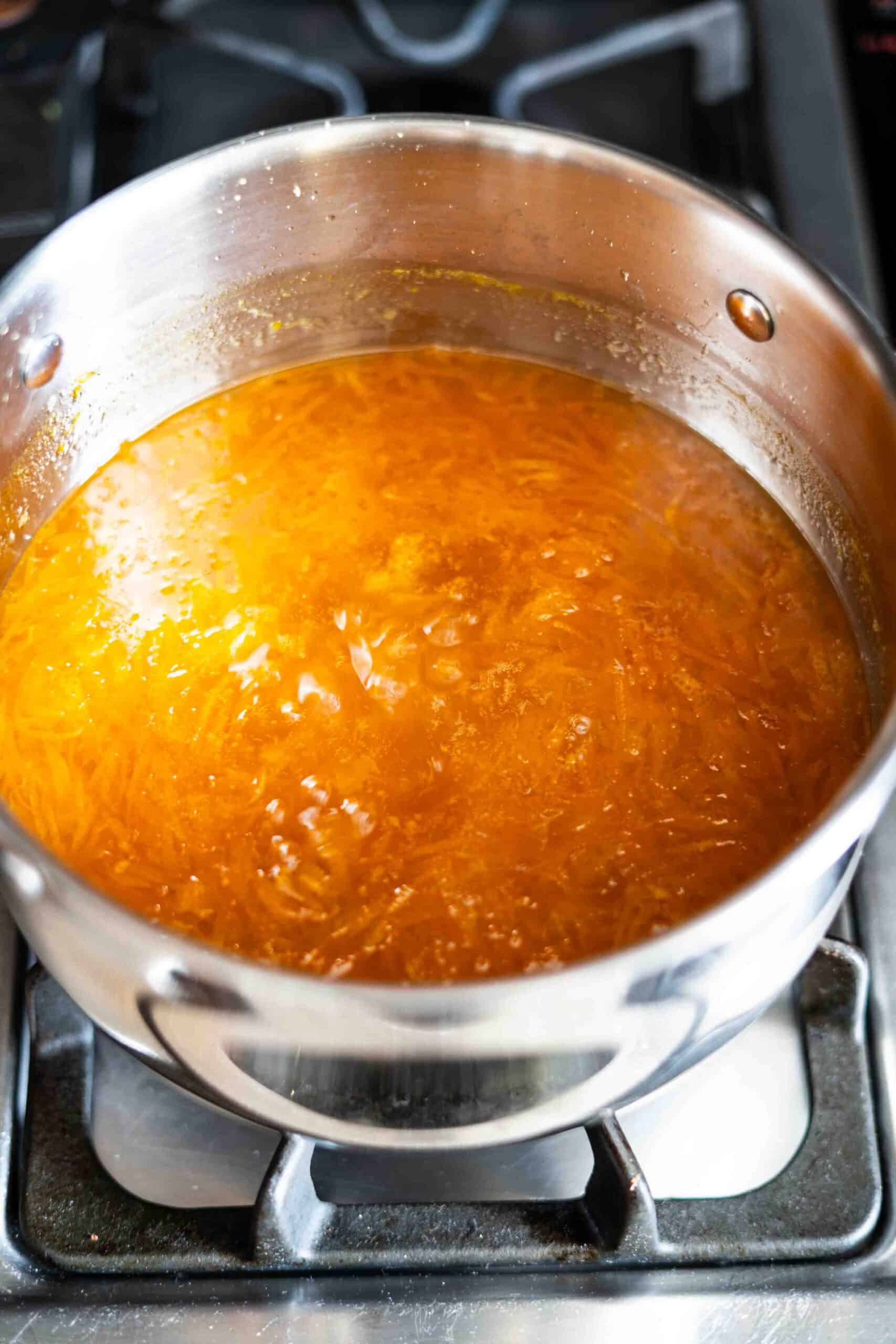 Orange jam mixture on the top of stove cooking