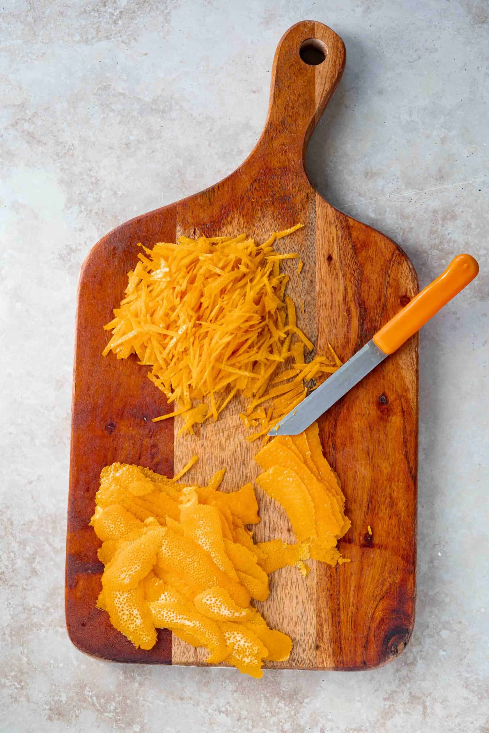 Oranges' skin peeled on a cutting board then thinly sliced.