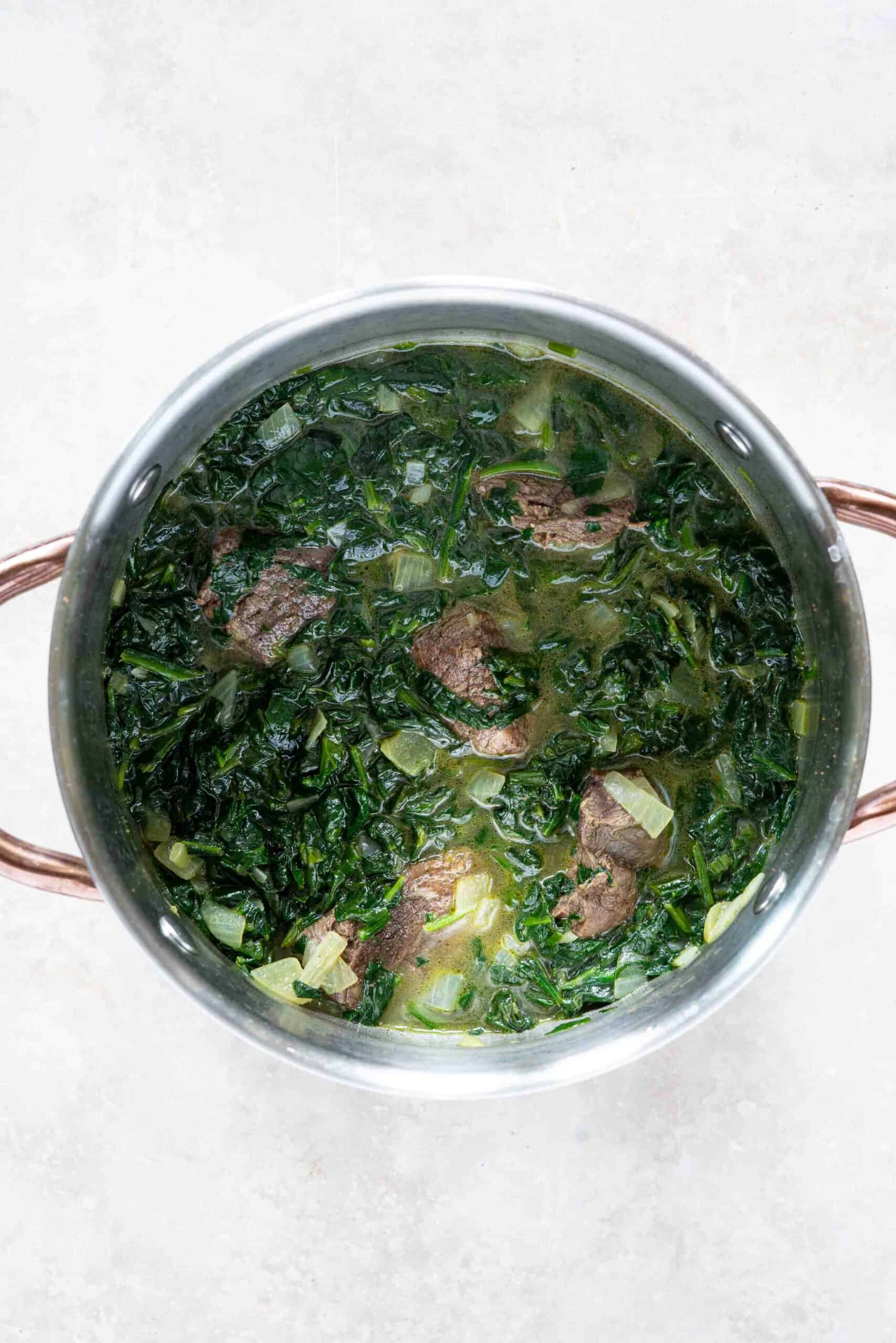 Cooked Spinach with lamb pieces in a pot