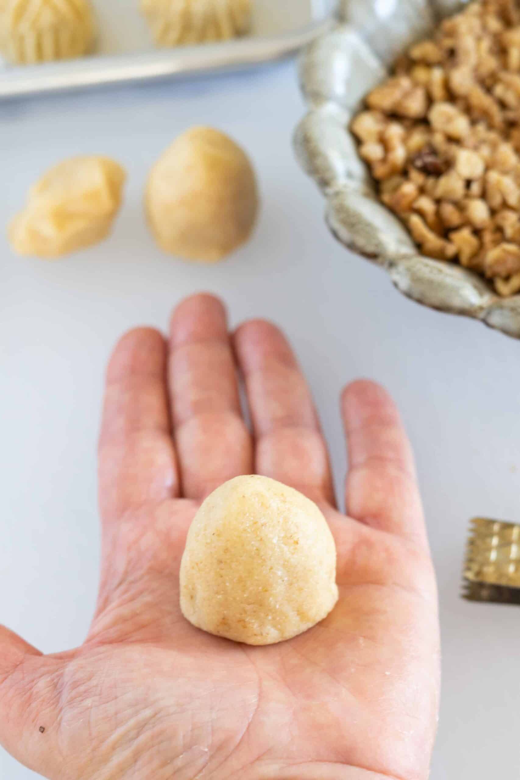 Holding dome-shaped maamoul walnut cookie in my hand.