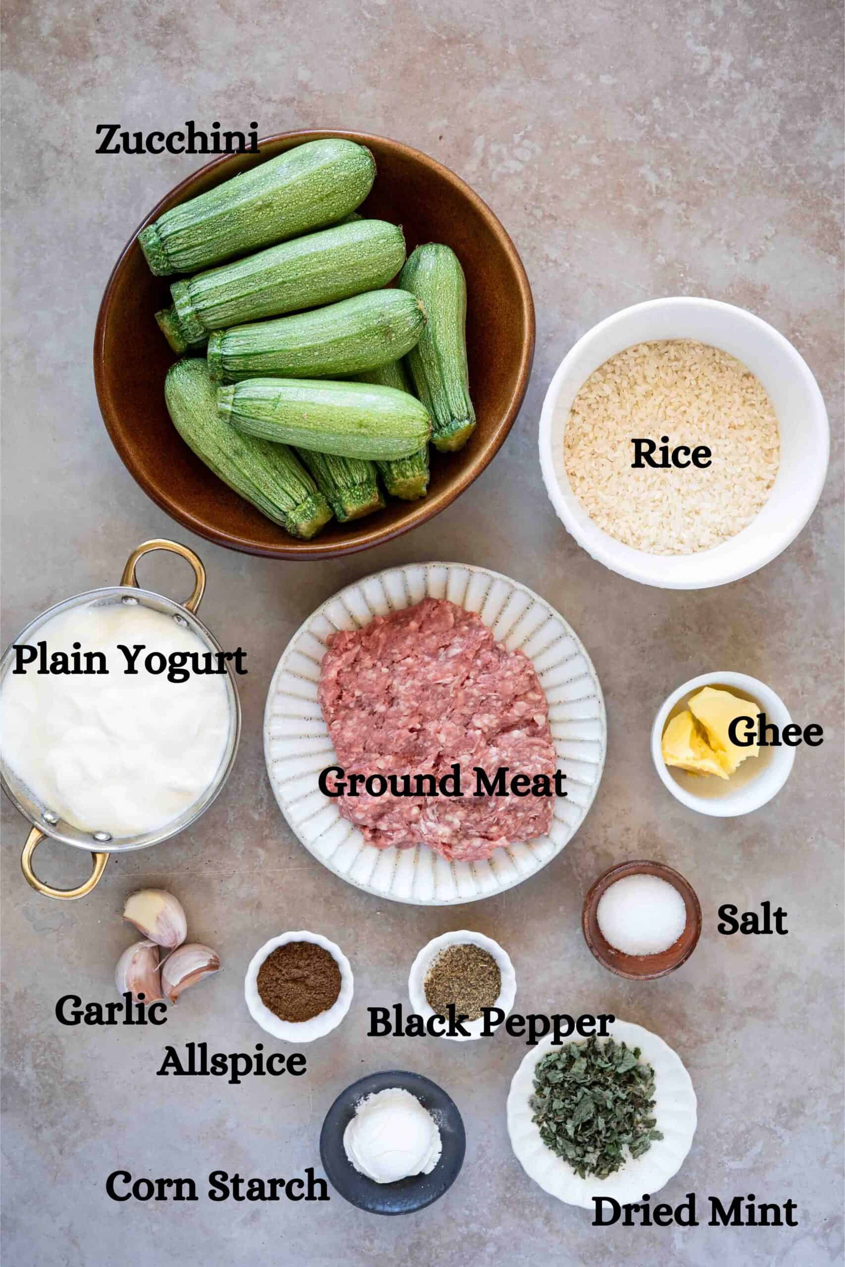 kousal bil laban ingredients: zucchini, rice, ground meat, plain yogurt, cornstarch, ghee, allspice, garlic, salt and black pepper, and dried mint for garnishing.