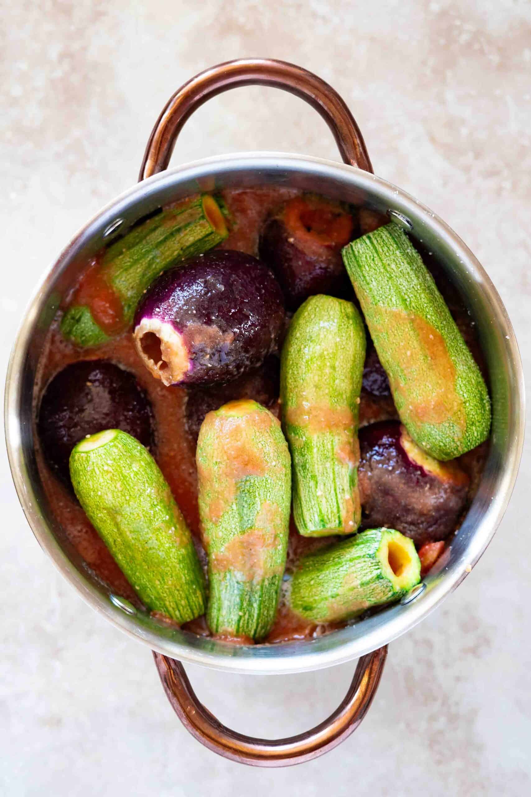 Mahshi stuffed and arranged in a pot with tomato sauce poured over it, ready for cooking.