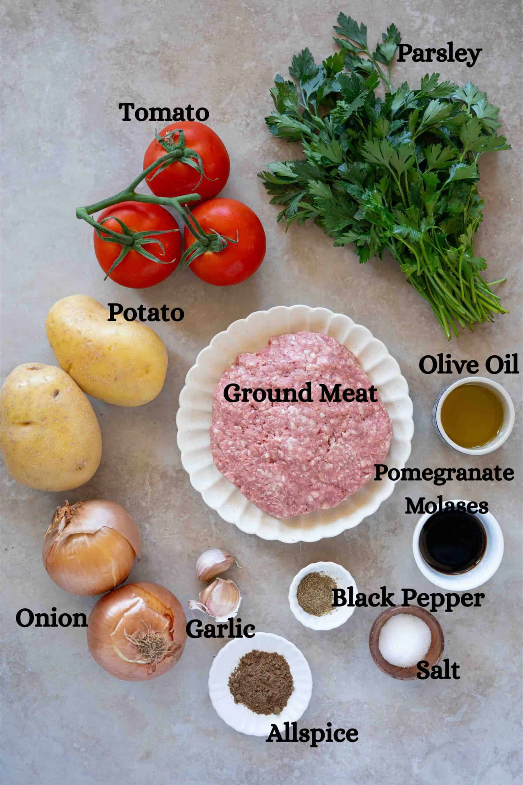 Kafta bi sanieh ingredients: ground meat, parsley, onion, garlic, potatoes, tomatoes, olive oil, pomegranate molasses, allspice, salt and black pepper.