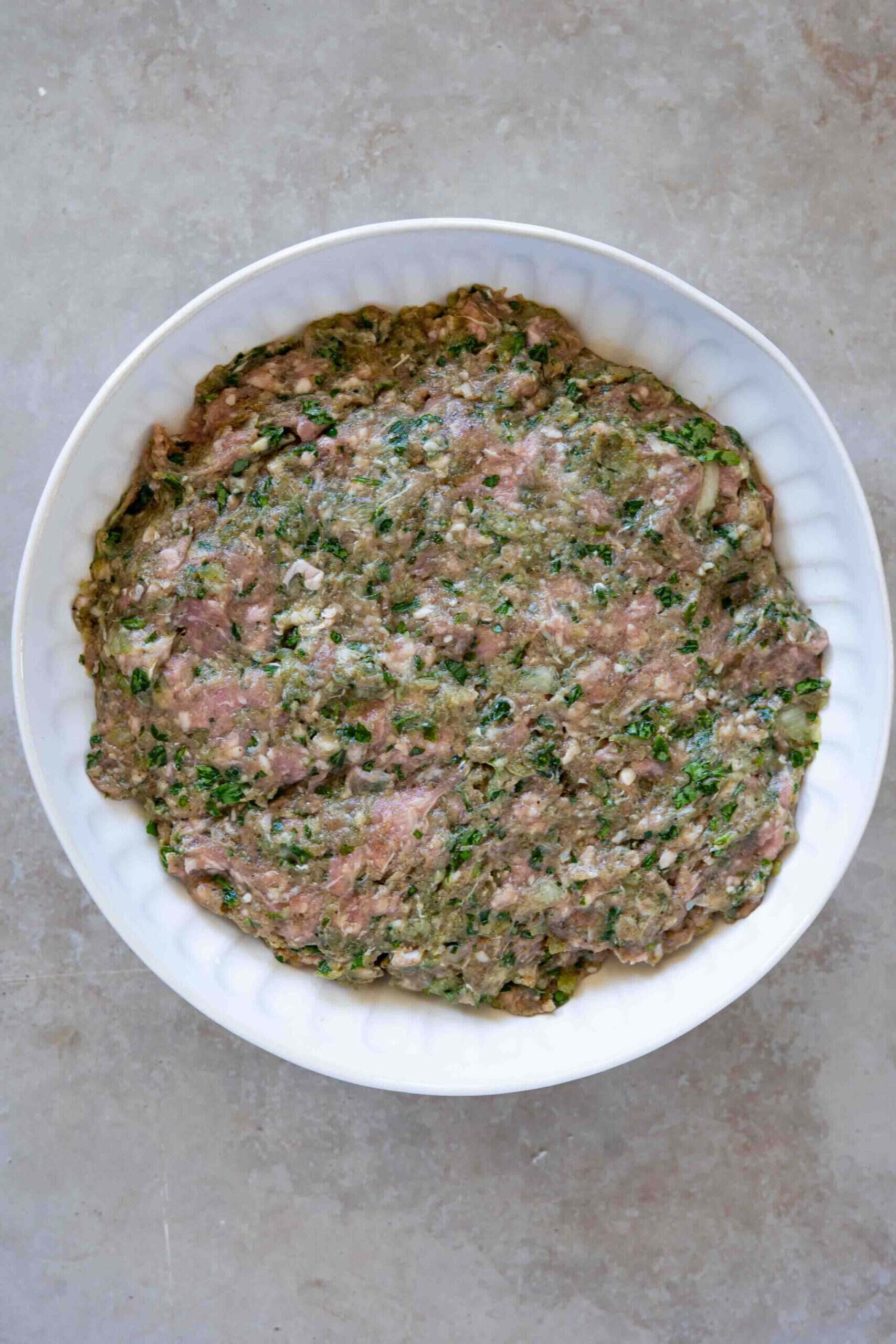 Kafta mixed: ground meat, parsley, pomegranate molasses, olive oil, salt and spices all mixed in a bowl.