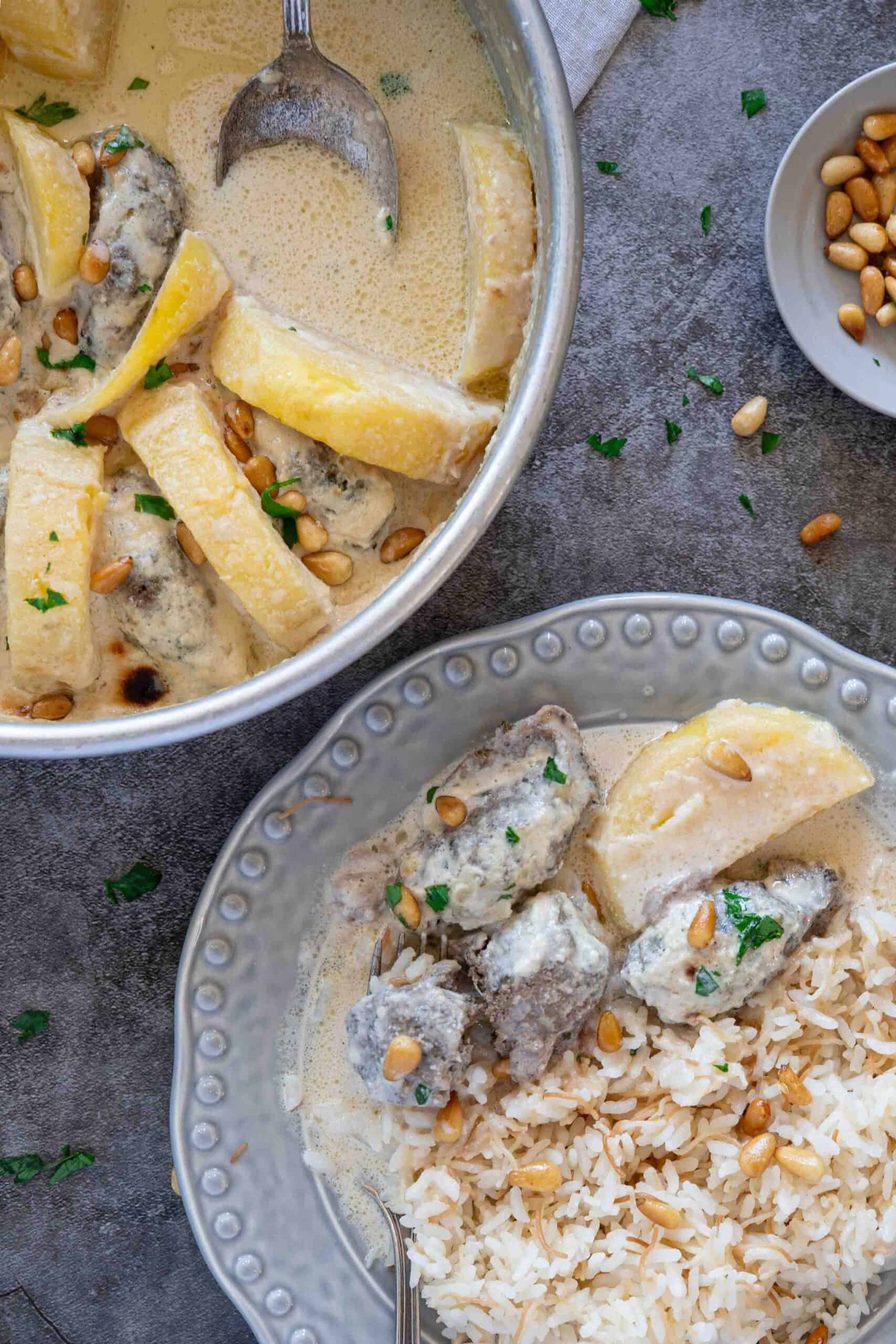 Baked Kafta bil Tahini served with vermicelli rice on a dinner plate beside the baking dish.