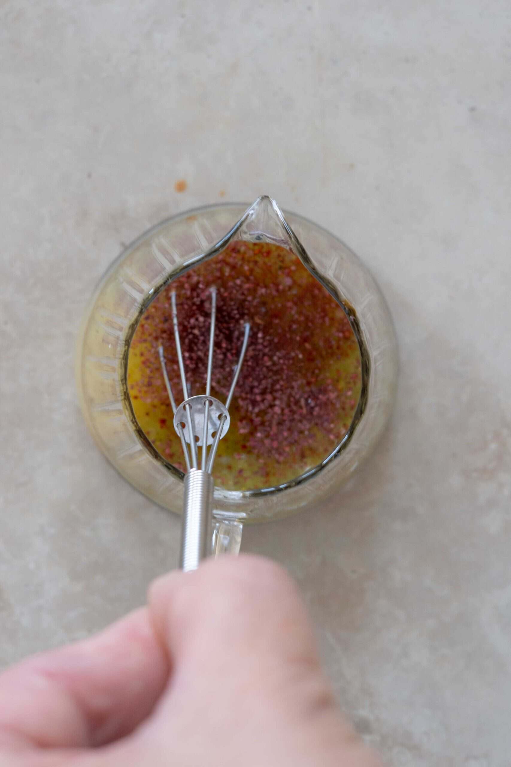 Stirring salad dressing ingredients in a small jar