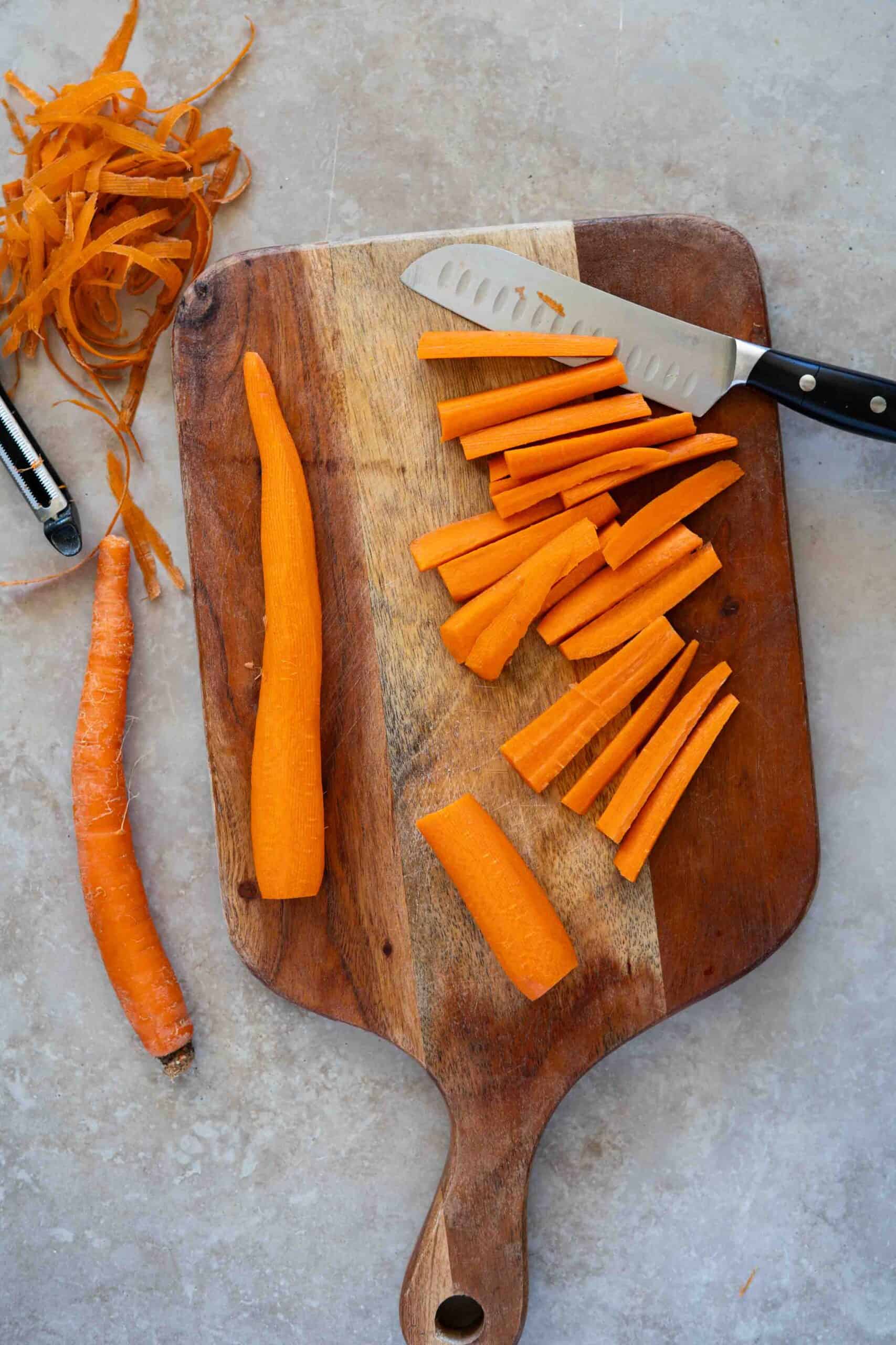 Peeling and slicing carrots using a knife and a cutting board