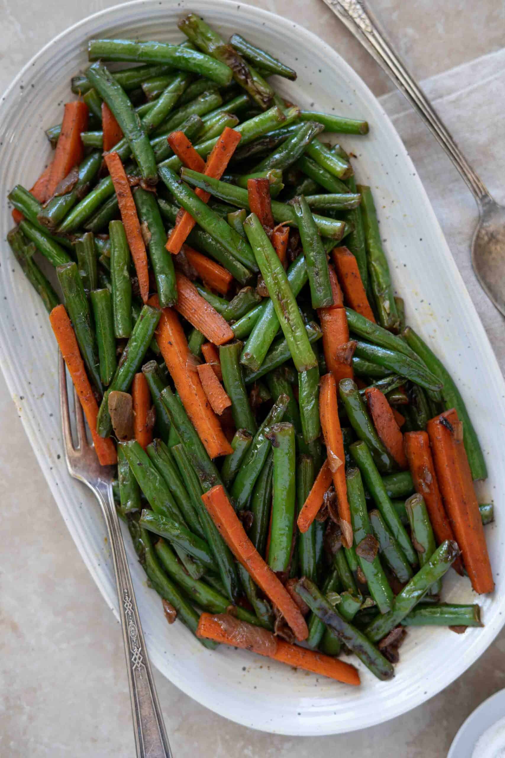A close up photo for green beans and carrots served in a plate